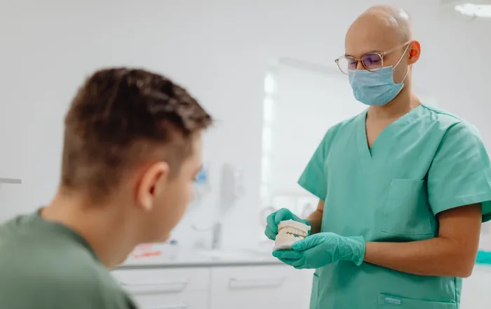 Un odontoiatra spiega un trattamento a un paziente