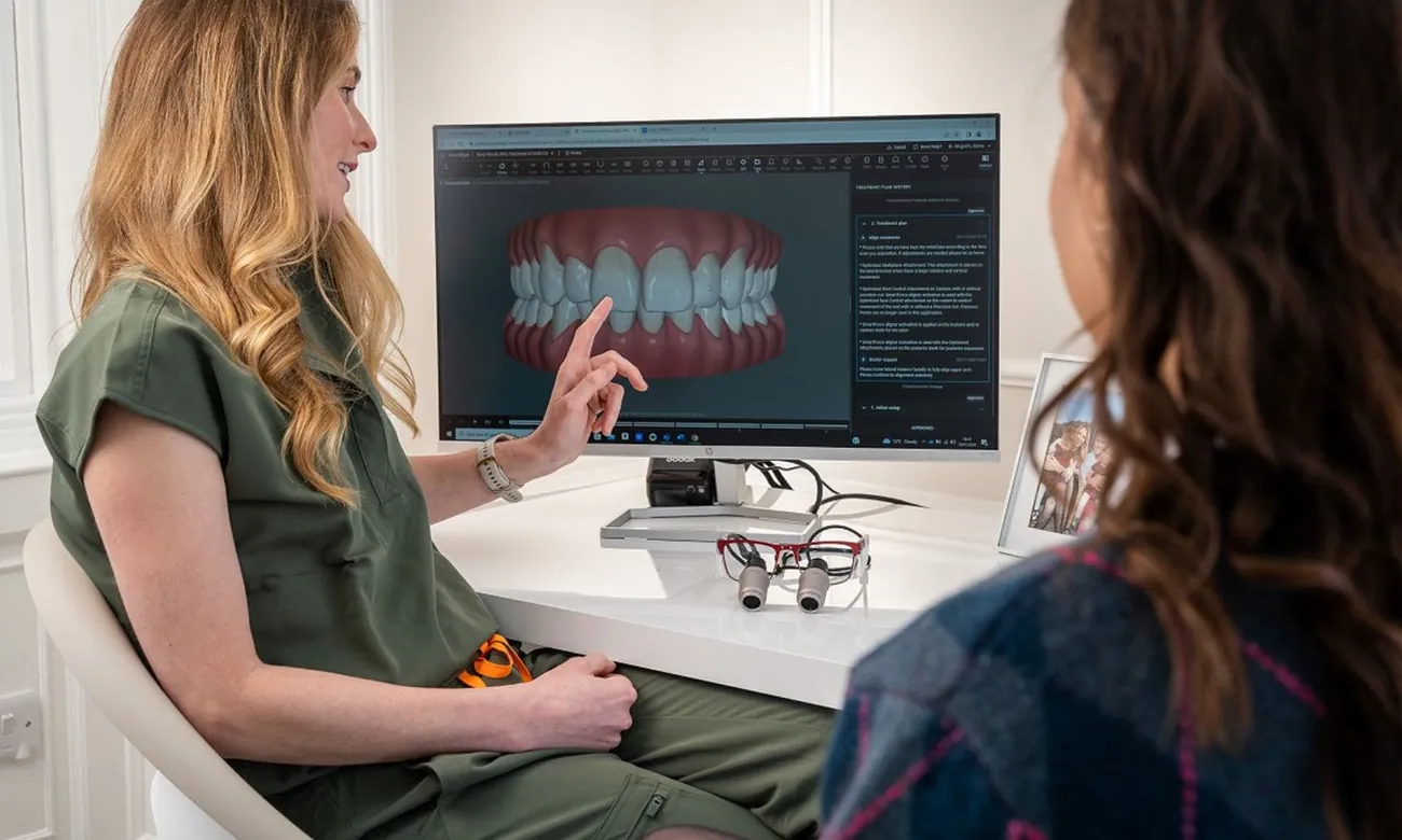 Un'odontoiatra mostra a una paziente il piano di cura sullo schermo